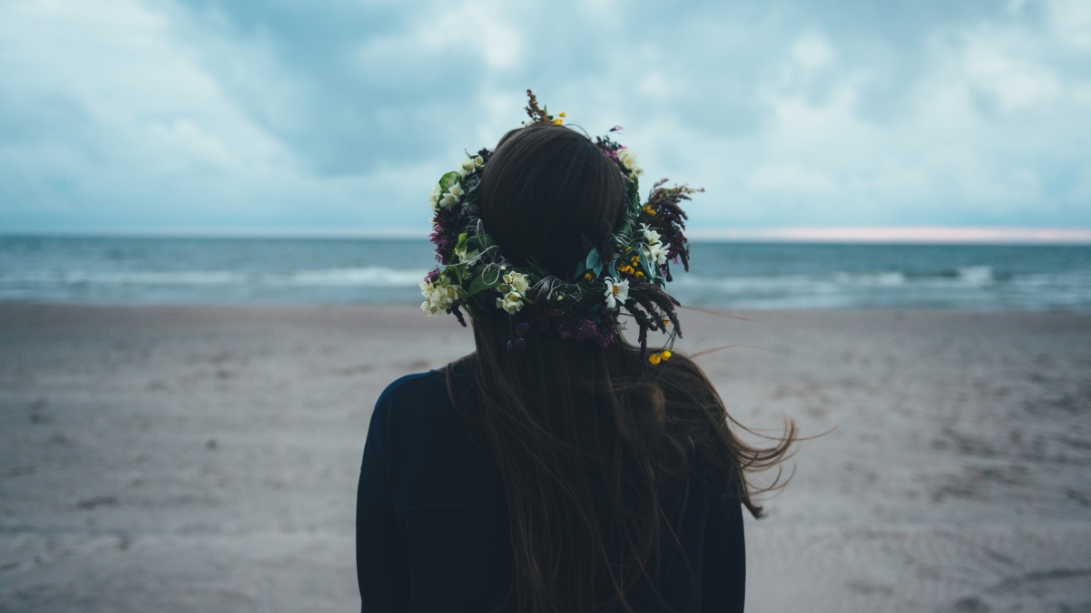 海边浪漫瞬间，女孩花环映衬下的海滩美景，超清4K壁纸下载