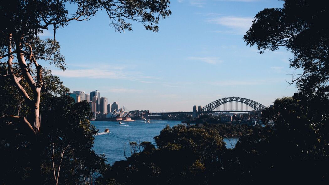 城市天际线美景，树影婆娑、建筑耸立、河流悠悠、船行其间，4K超清壁纸（3840x2160）免费下载
