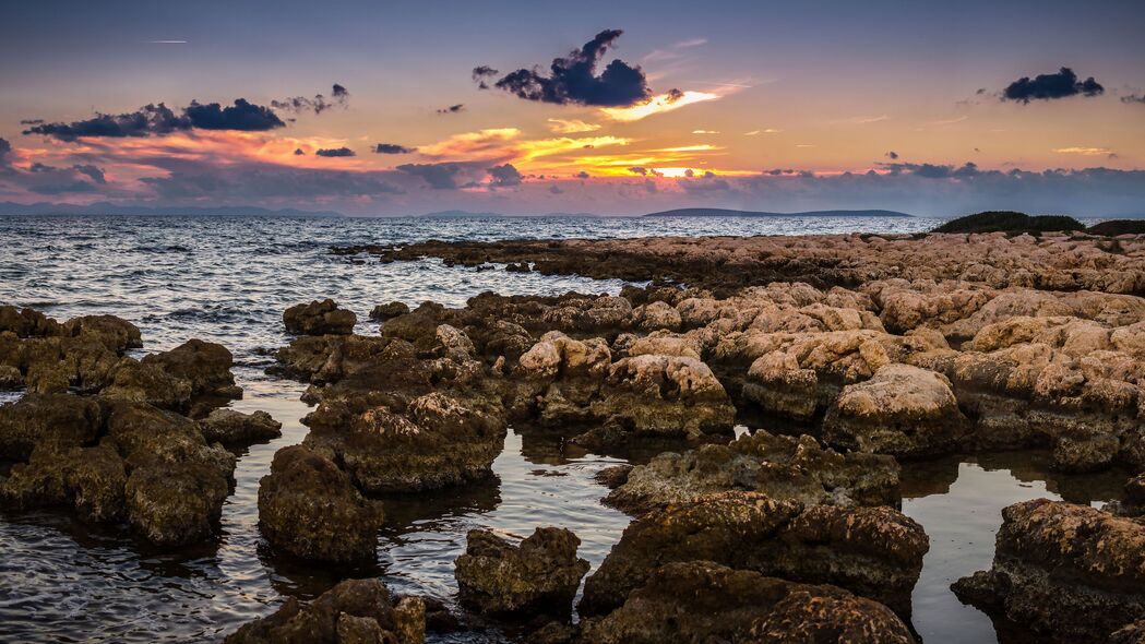 海岸落日美景，石头与大海交织的自然画卷，高清4K壁纸3840x2160免费下载