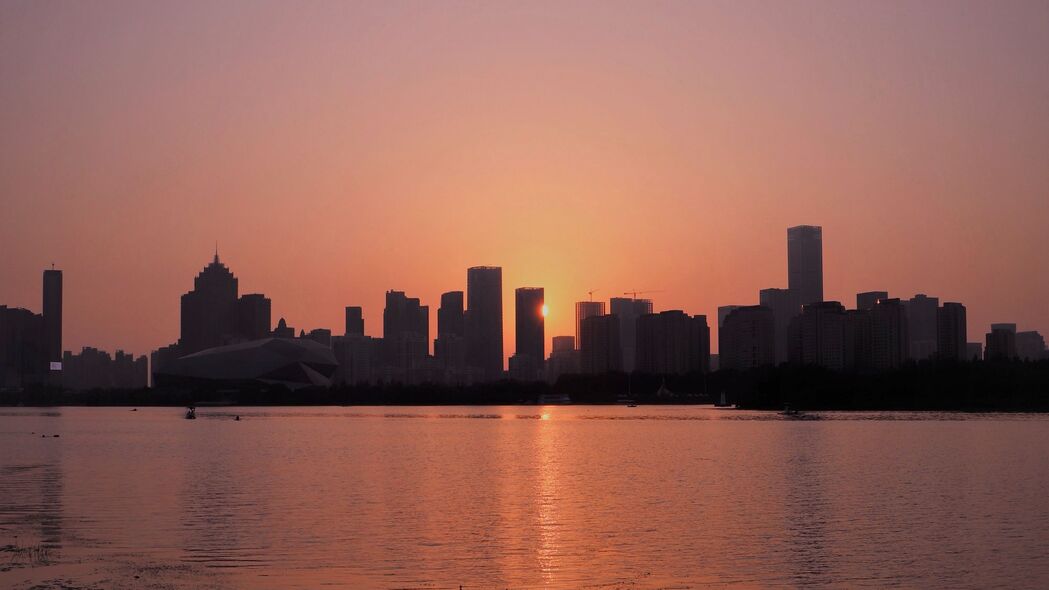 日落余晖映城市，建筑光影交织，海洋壮阔入画——4K超高清3840x2160风景壁纸下载