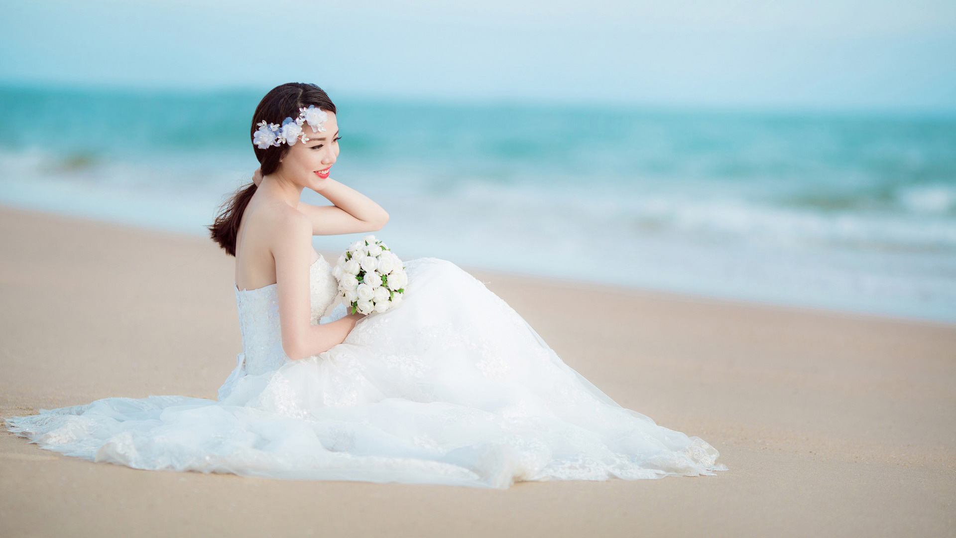 新娘微笑倩影，婚纱礼服配鲜花，沙滩大海映美照，美女婚纱照壁纸免费下载