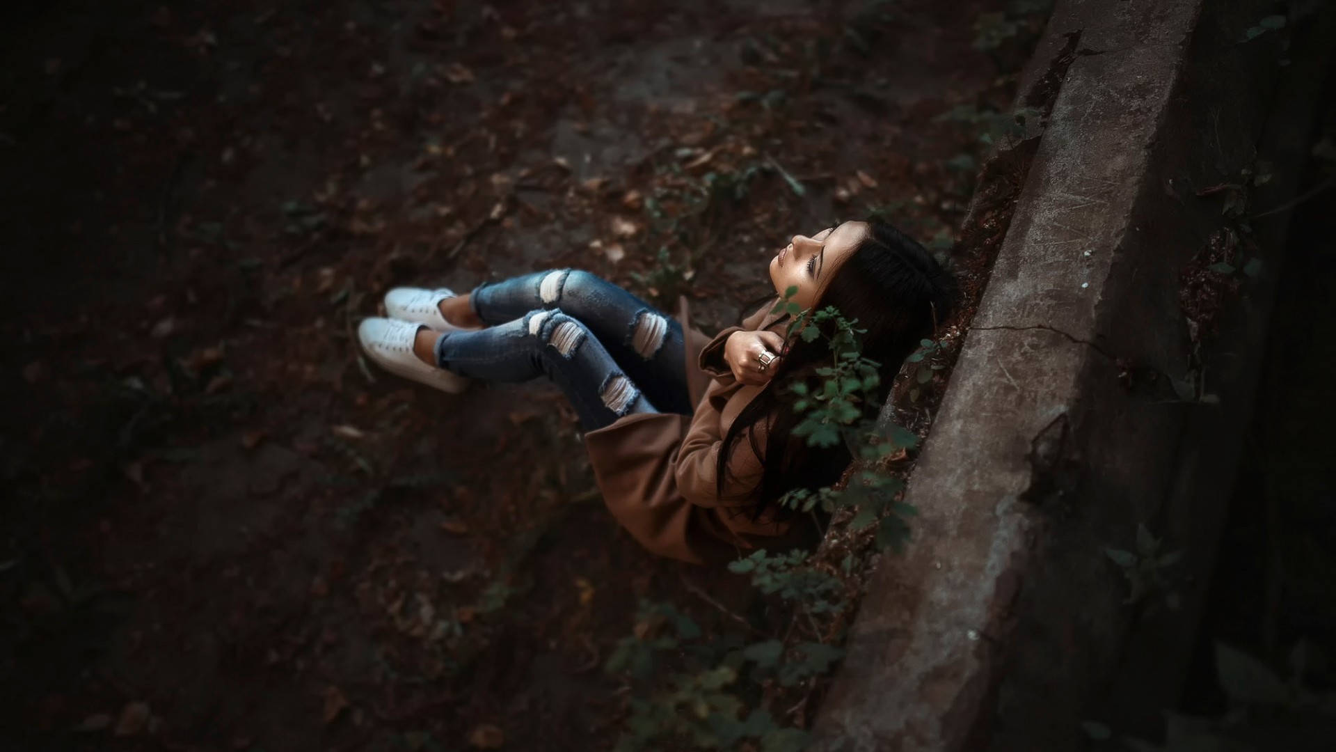 美女孤单倚墙，牛仔裤映公园景，非主流壁纸免费下载
