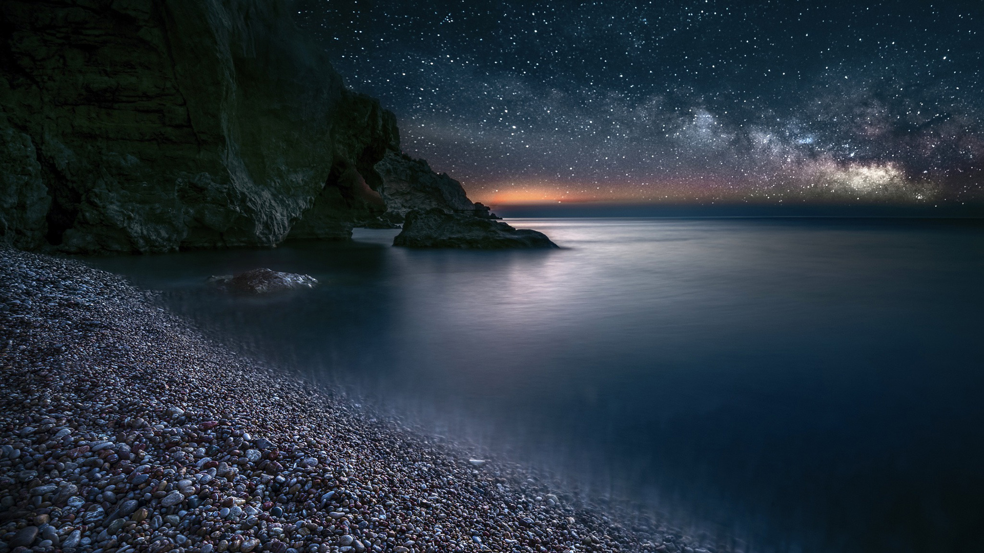 海滩星空夜景，岩石与星星交织的绝美风景桌面壁纸，免费下载！