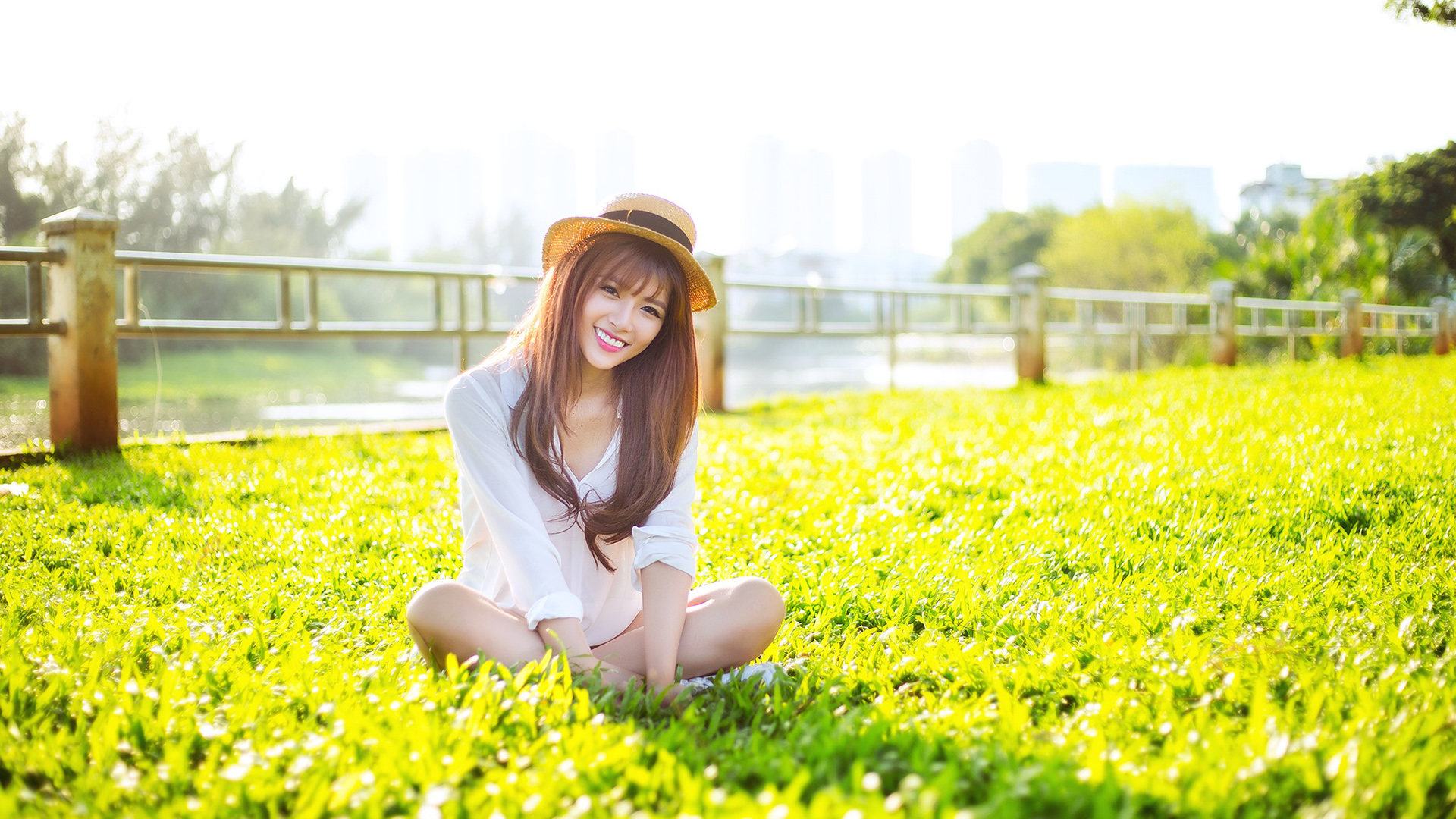 夏日公园草地上的微笑女神，优雅盘腿坐姿桌面壁纸，免费电脑壁纸高清下载