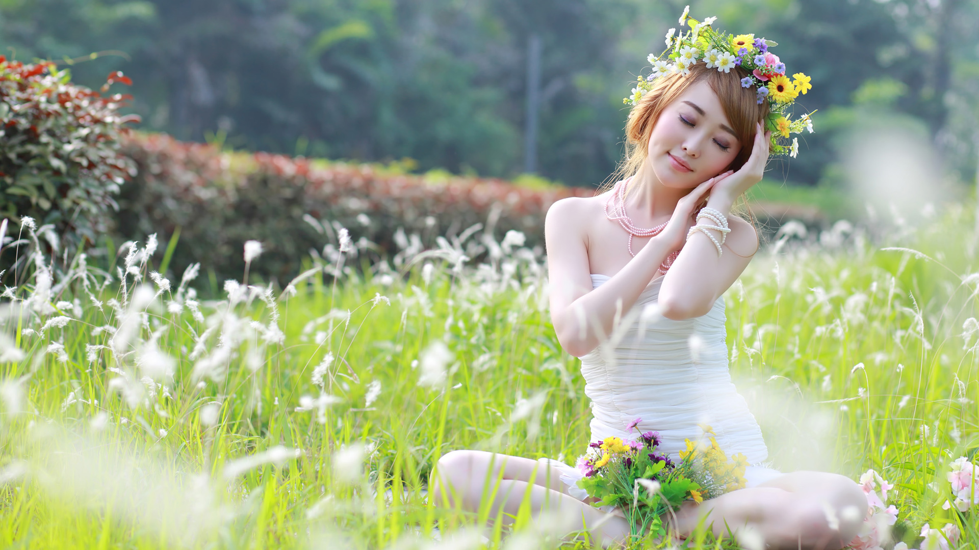 草地花香中的美女坐姿写真，花环映衬下的陶醉时刻，免费下载高清桌面壁纸