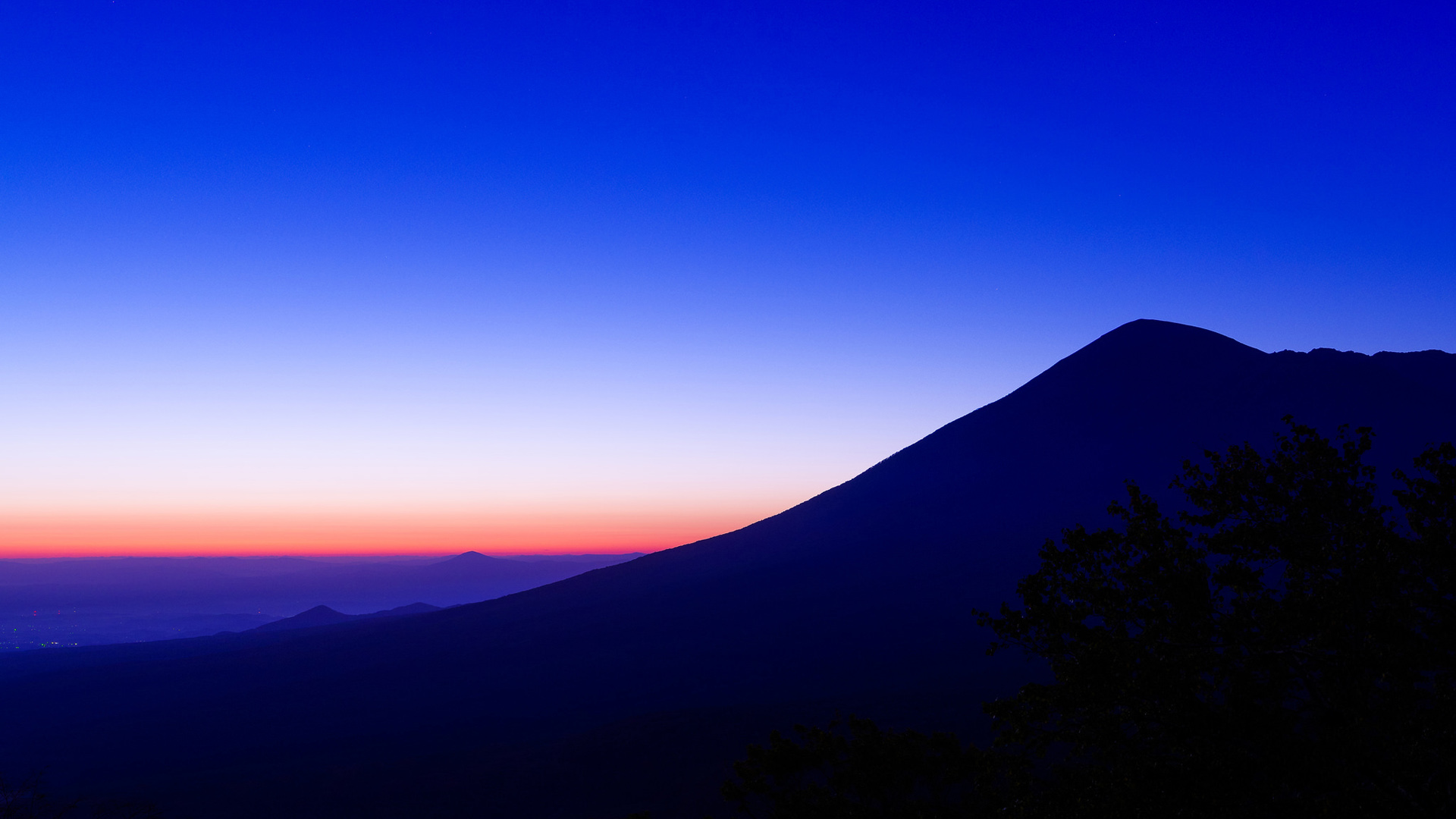免费下载，天空发光，山树相映的自然风景桌面壁纸，尽享自然之美！