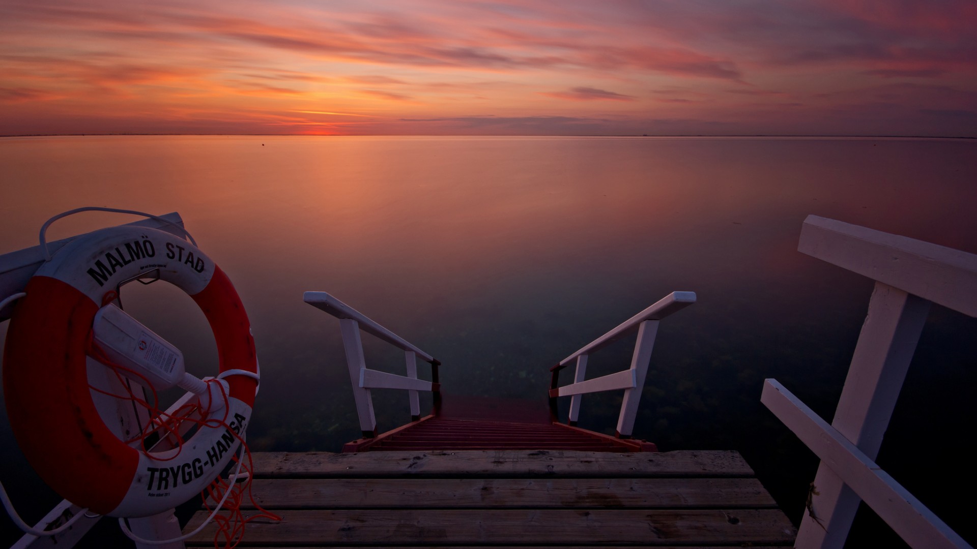 免费下载，夕阳余晖映海湾，码头美景成壁纸，尽享绝美风景画面！