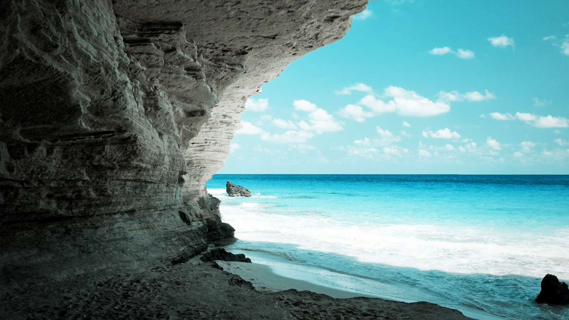 海洋洞穴奇观，水石交融，蓝色天空下的绝美风景——免费电脑桌面壁纸下载