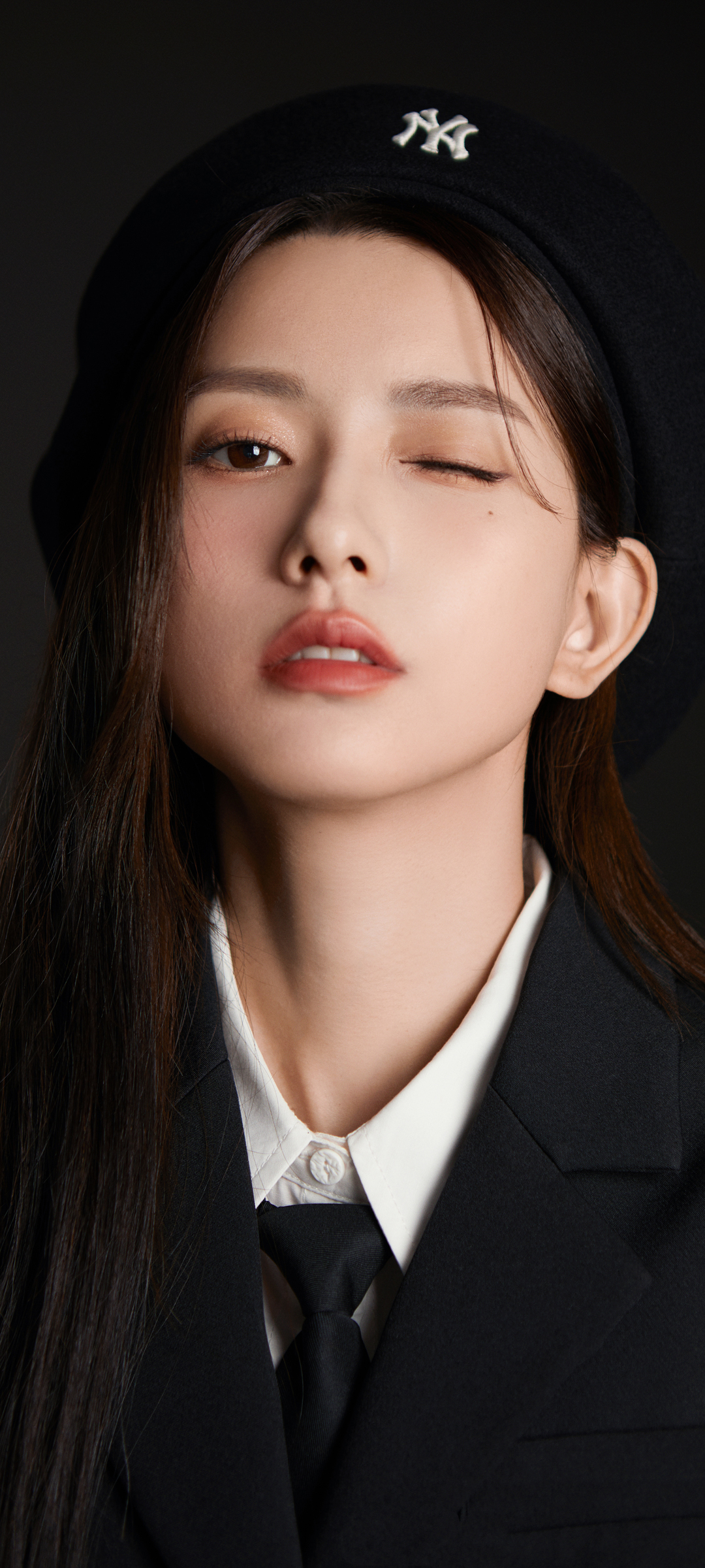 黑西装美女俏皮闭眼，手机壁纸免费下载，可爱风格任你选！