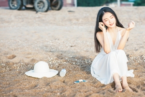 可爱美女坐在沙滩听音乐4k壁纸